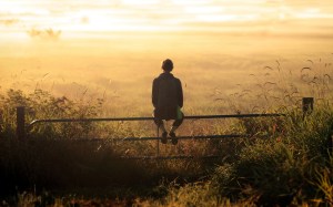girl-backpack-thinking-sunset-field-fence